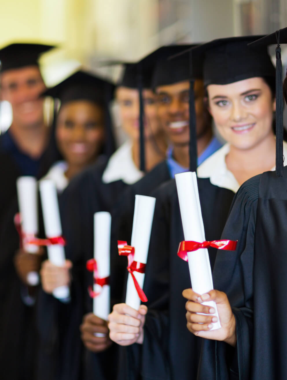 students graduating and holding diplomas